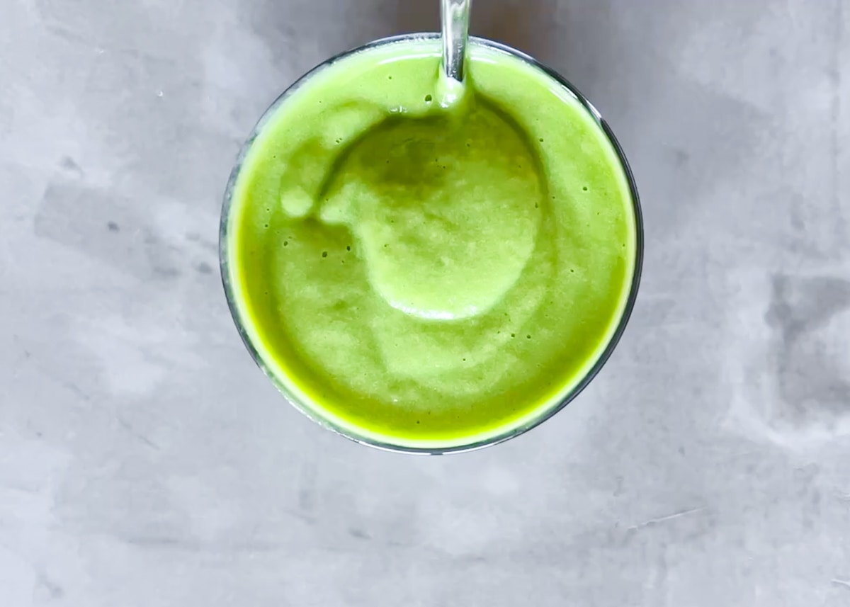 Daily harvest pineapple matcha smoothie in a glass.