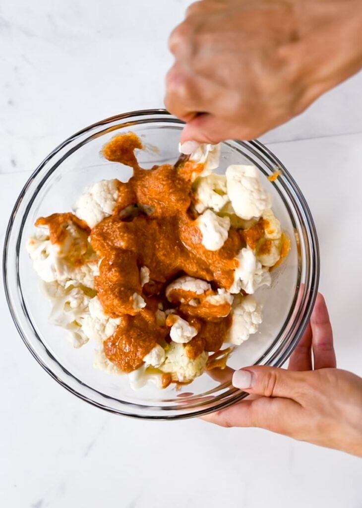 Adding the batter to cauliflower wings.