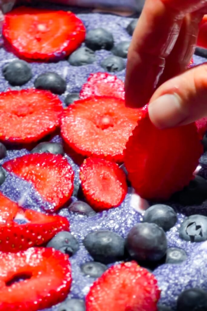 Adding the strawberries to the Refined Sugar Free Ice cream cake.